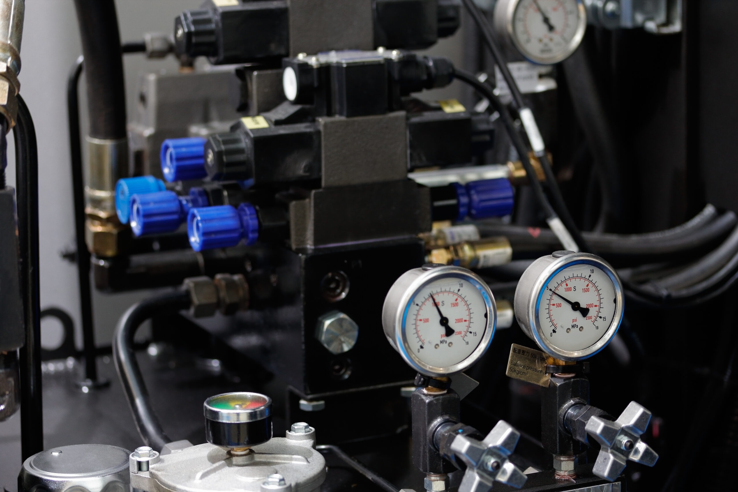 A close-up of the hydraulic system of a CNC machine, including the motor and pump