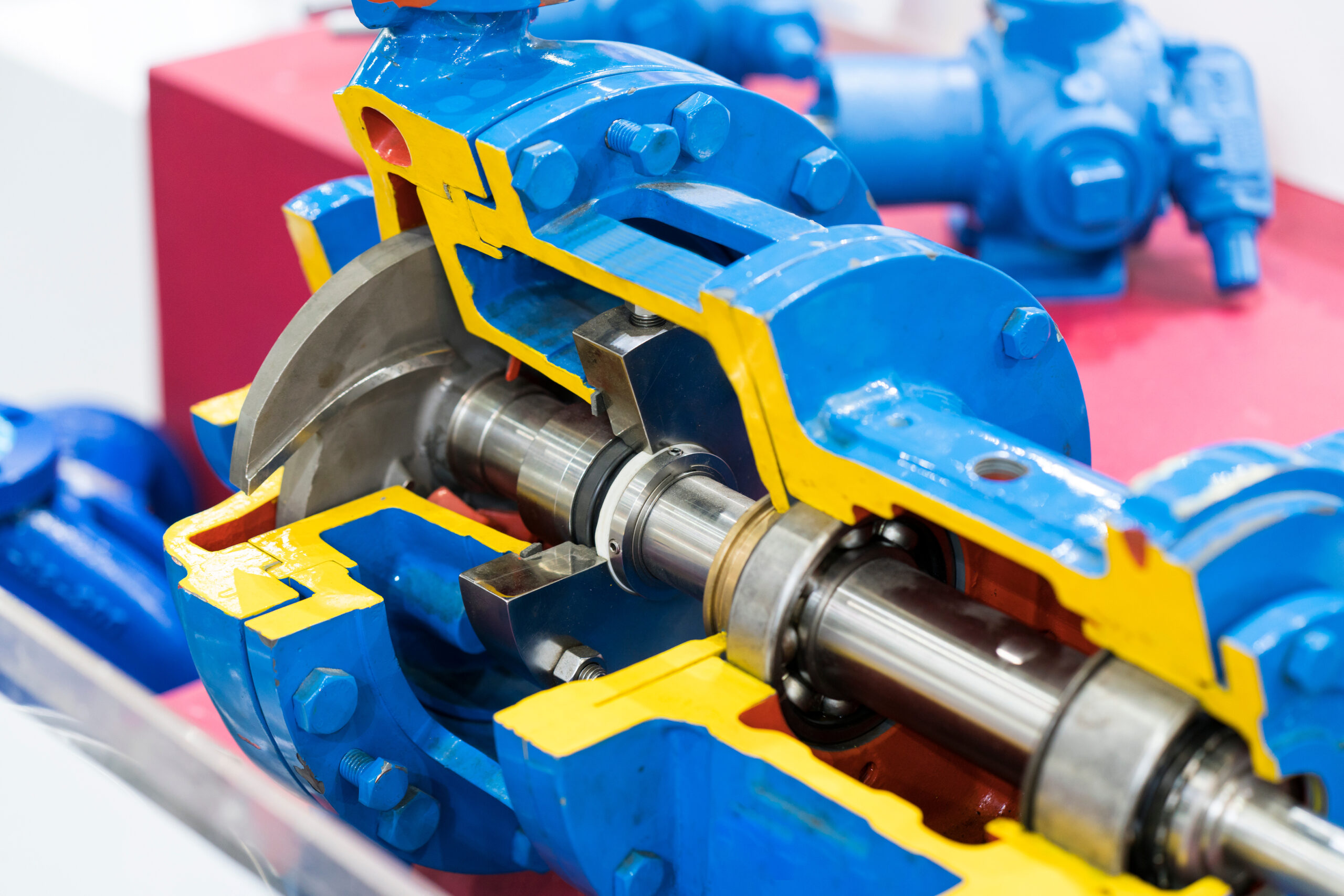 a blue hydraulic pump with fixed displacement is opened, allowing the viewer to see the piston within it.